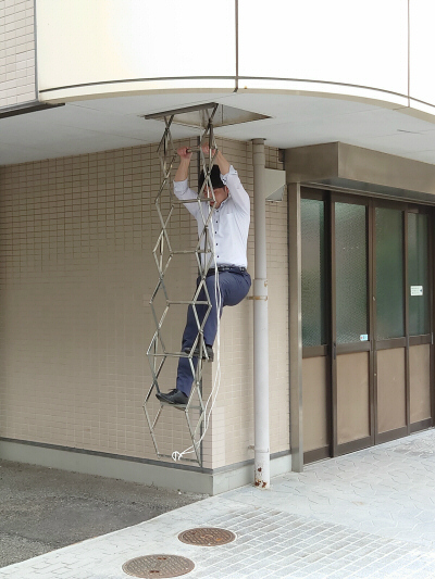 ベランダから非常用はしごを使って降りてくる人
